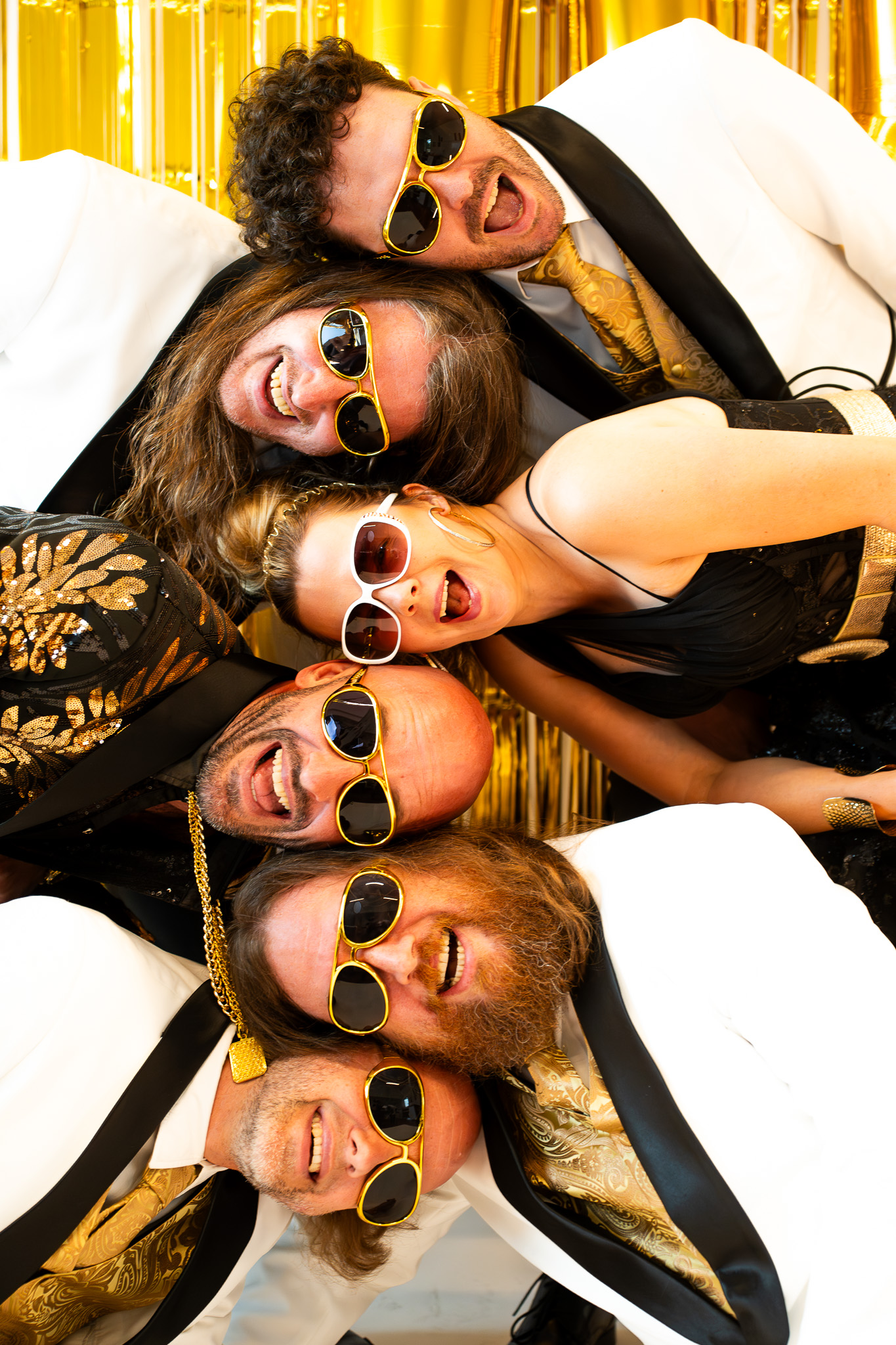 Faute Bendt band groepsfoto - 6 bandleden met gouden zonnebrillen en witte kostuums poseren samen voor fotoshoot